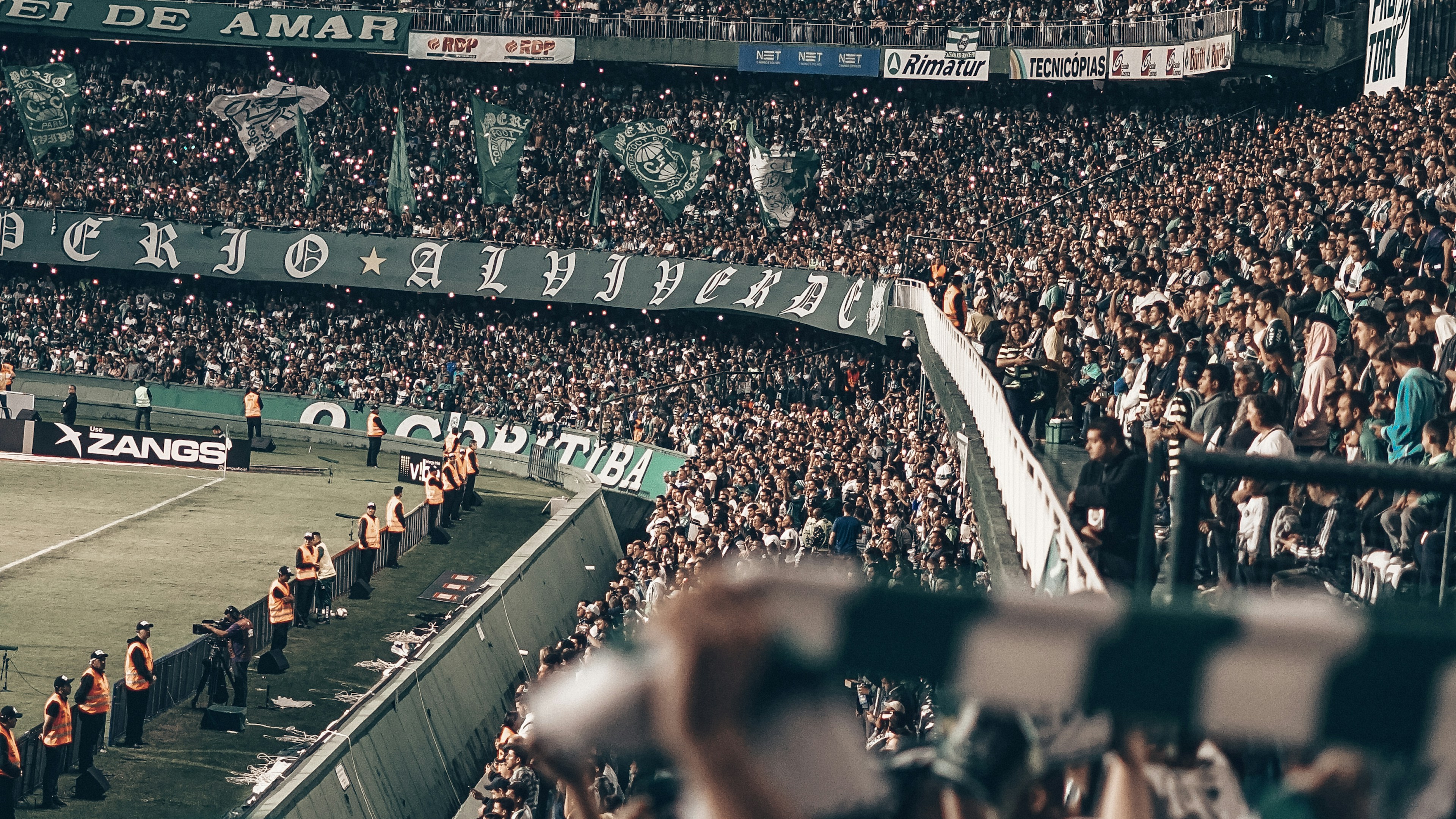 A real crowd filling a stadium during a night match